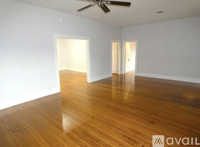 A room with wooden floors and a ceiling fan.