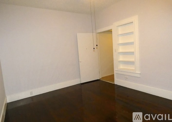 A room with a white door and a white shelving unit.