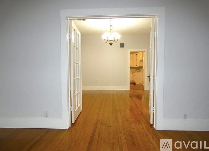 A room with a wooden floor and a chandelier.