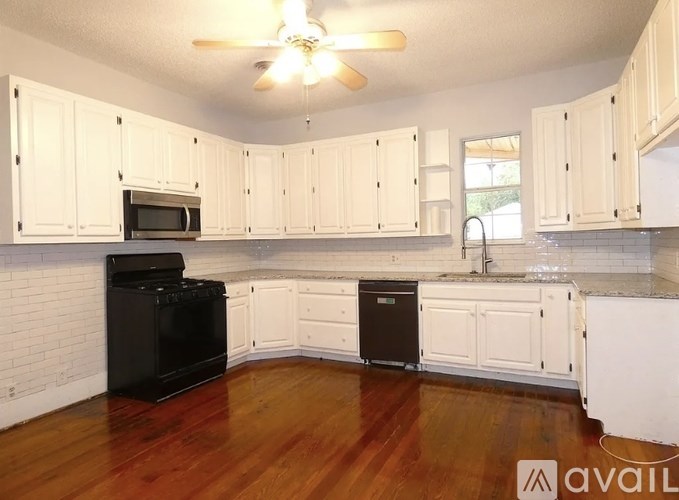 A kitchen with white cabinets and a black oven.