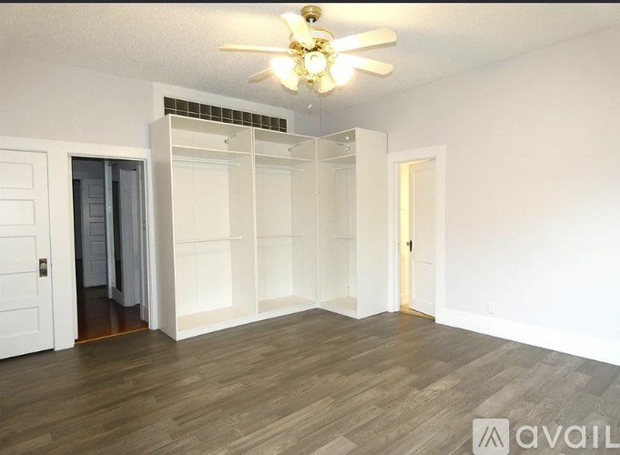 A room with a ceiling fan and a sliding door.