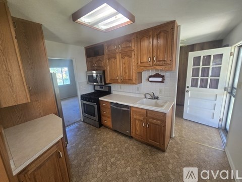 A kitchen with wooden cabinets and a patterned floor.