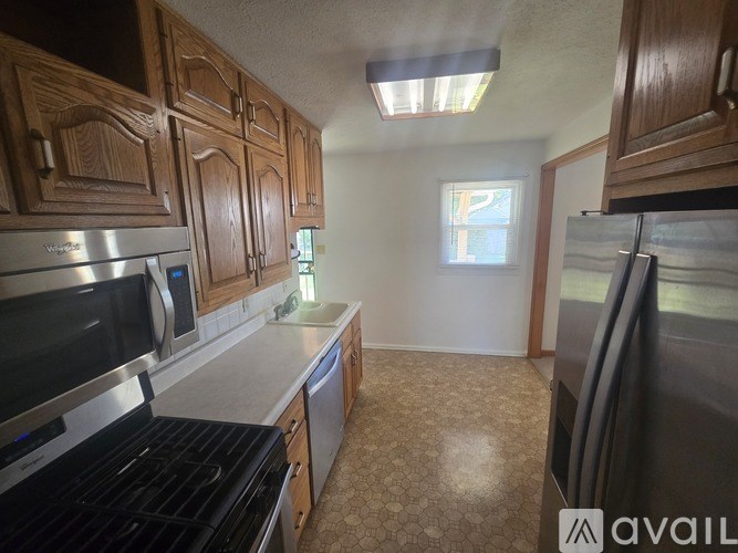 A kitchen with wooden cabinets and a window.