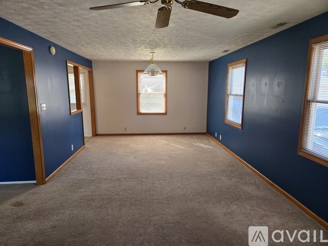 A room with blue walls and a ceiling fan.