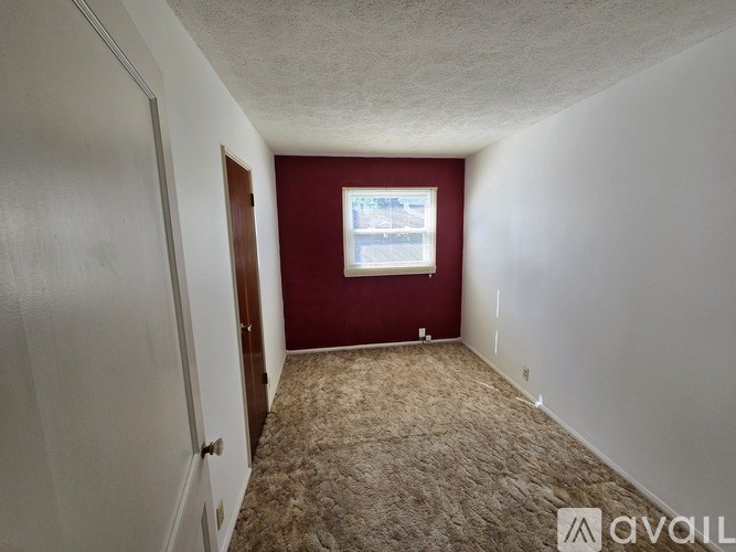 A room with a carpeted floor and a window.