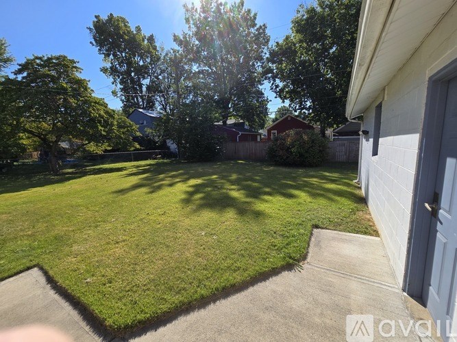 A backyard with a well-maintained lawn and a house in the background.