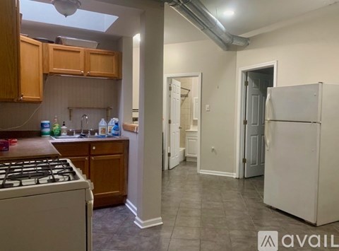 A kitchen with a white stove top oven and a white refrigerator.