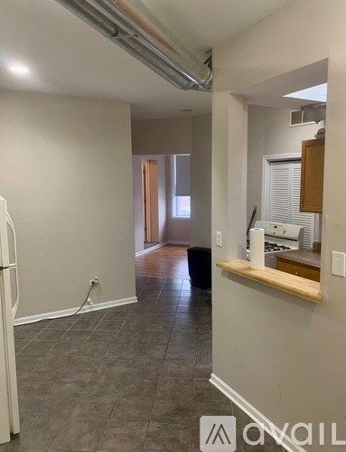 A kitchen area with a white fridge and a counter with a sink.