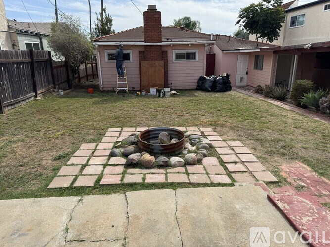 A backyard with a brick patio and a fire pit.