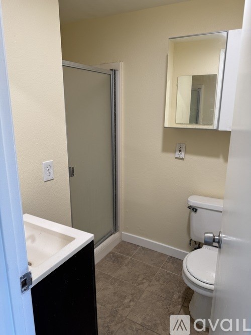 A bathroom with a toilet, sink, and mirror.