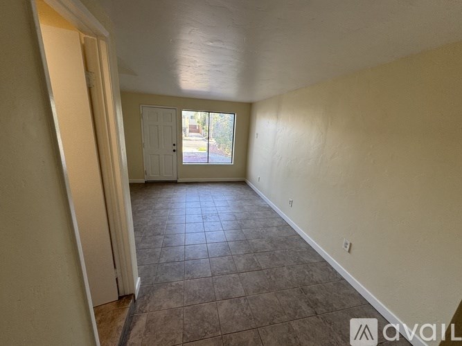 Empty room with tiled floor and white walls.