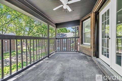 A patio with a ceiling fan and sliding glass doors.