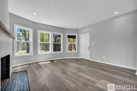 A spacious room with a fireplace and large windows.