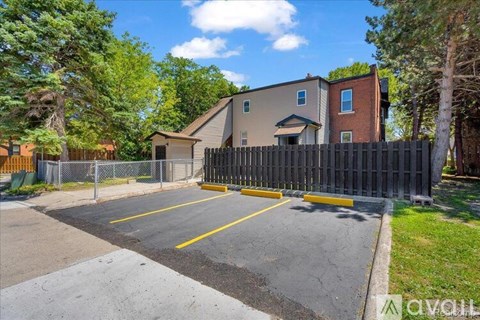 A parking lot with a fence and a building in the background.