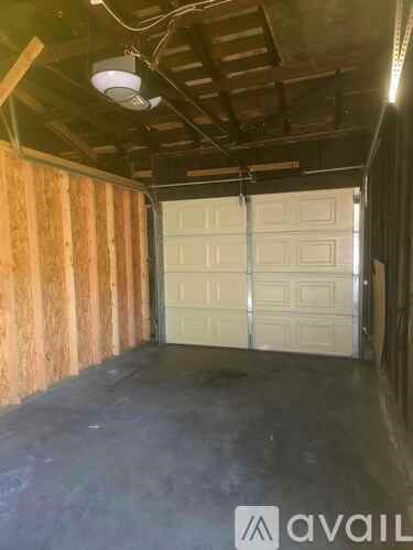 A large garage with a white door and wooden walls.