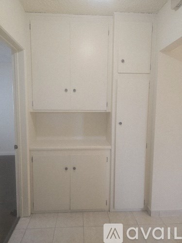 A white kitchen with a cabinet and a door.