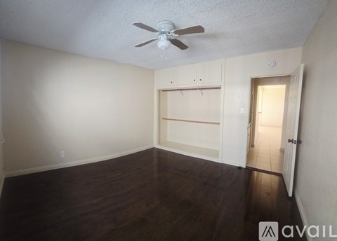 Empty room with a ceiling fan and wooden flooring.