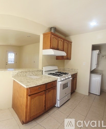 A kitchen with a white counter top and wooden cabinets.