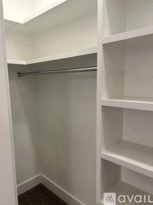 A white closet with shelves and a hanging rod.