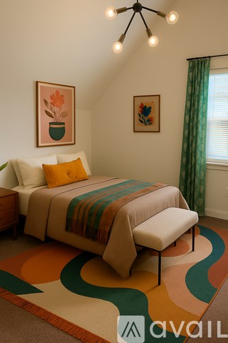 A bedroom with a bed, a bench, and two framed pictures on the wall.
