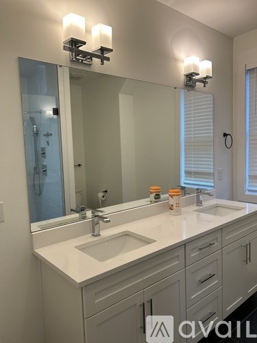 A bathroom with a sink, mirror, and cabinets.