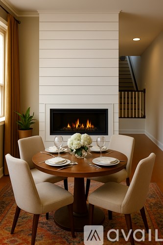 A dining room with a fireplace and a table set for two.