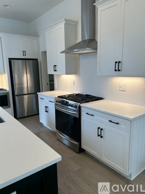 A kitchen with white cabinets and a black stove top.