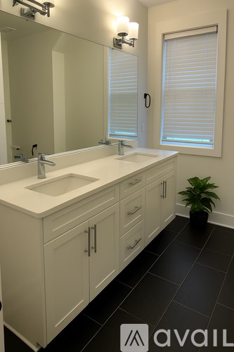 A bathroom with two sinks and a large mirror.