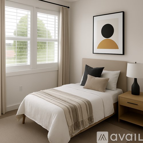 A bedroom with a bed, nightstand, and a framed picture on the wall.