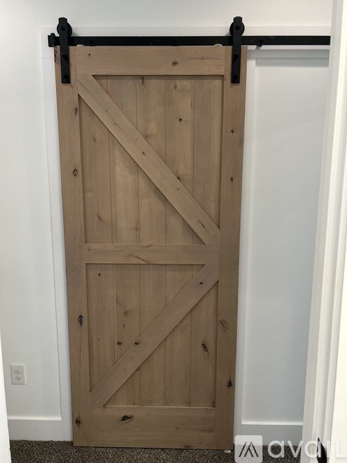 A wooden door with a black handle.