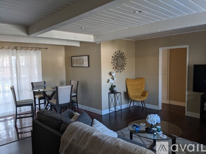 A living room with a grey couch and a yellow chair.