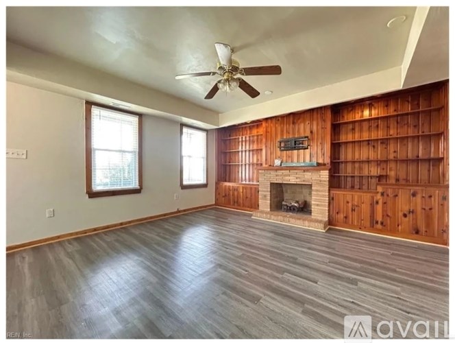A spacious room with wooden walls and a fireplace.