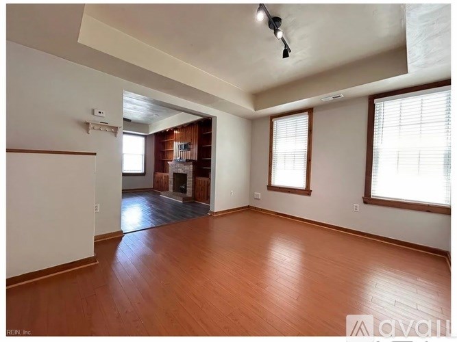 A room with wooden floors and a white wall.