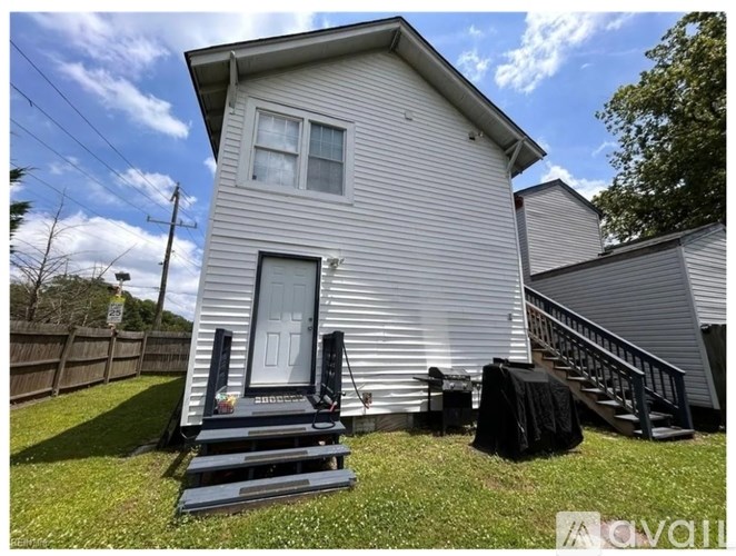 A house with a grey siding and a white door is shown.