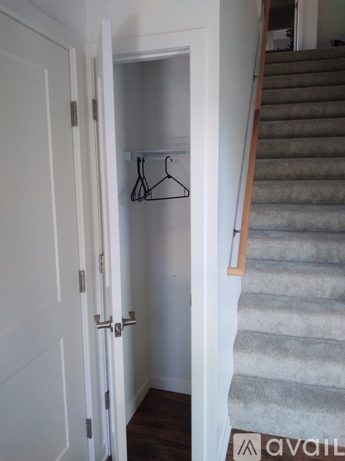 A white door is open to a hallway with a staircase.