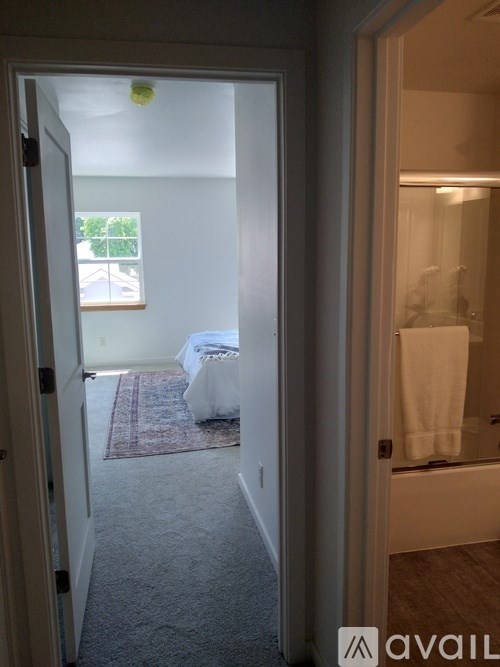 A room with a bed and a bathroom visible through the door.