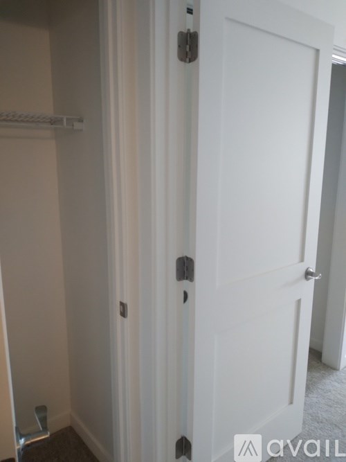 A white door with a silver handle and a silver lock.