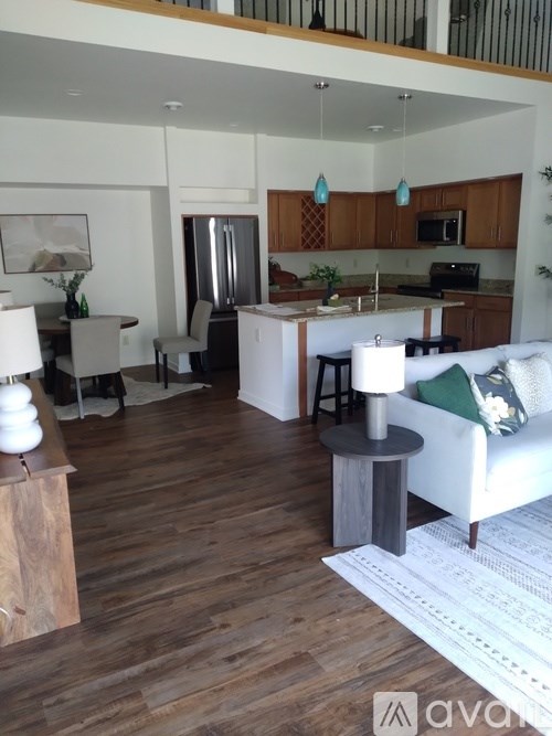 A modern kitchen with wooden floors and a white sofa.