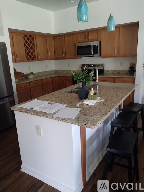 A kitchen with wooden cabinets and a granite countertop.