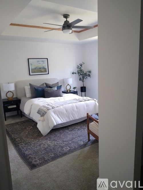 A bedroom with a large bed and a ceiling fan.