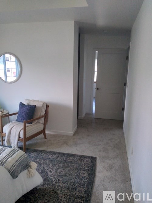 A bedroom with a bed, a chair, and a rug.