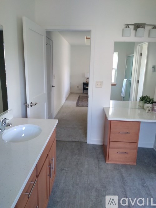 A bathroom with a sink, mirror, and wooden cabinets.