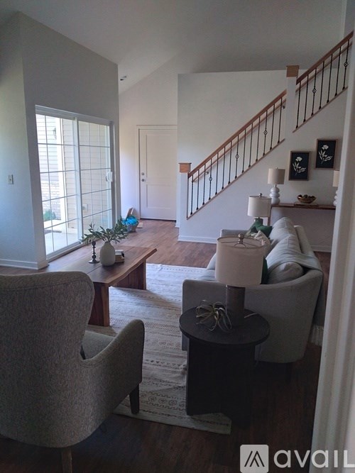 A living room with a chair, a table, and a couch.