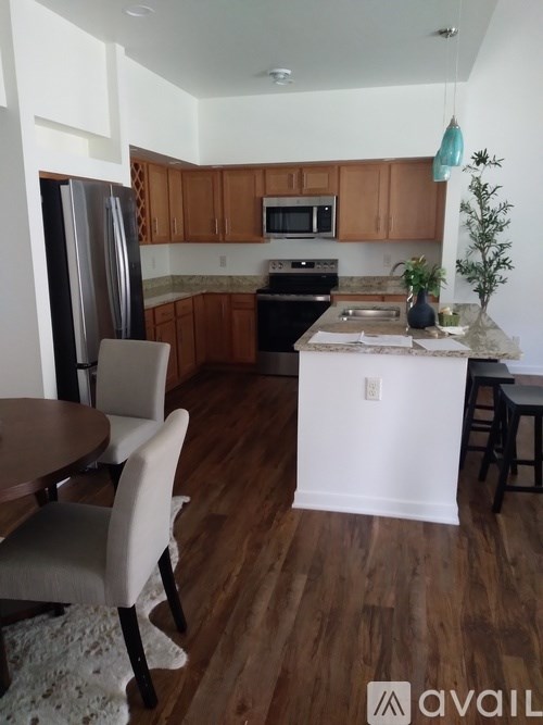 A kitchen with wooden floors and a white wall.