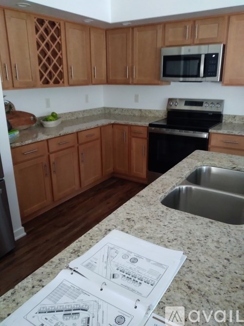 A kitchen with wooden cabinets and a granite countertop.