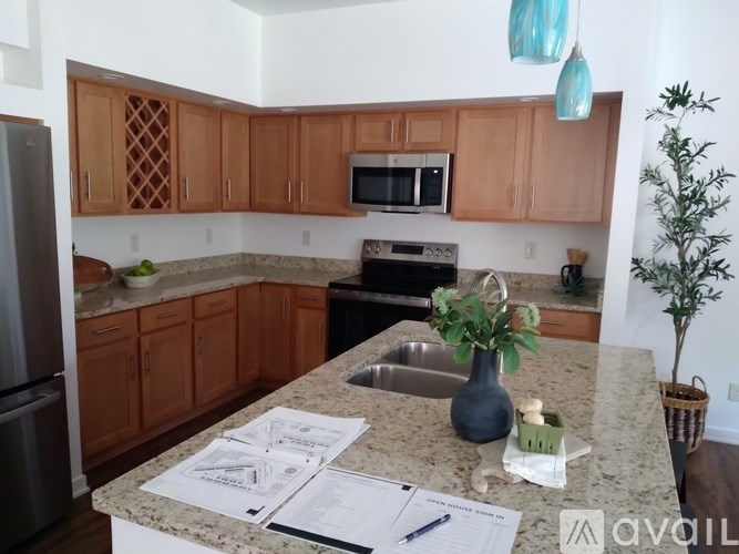 A kitchen with brown cabinets and a granite countertop.