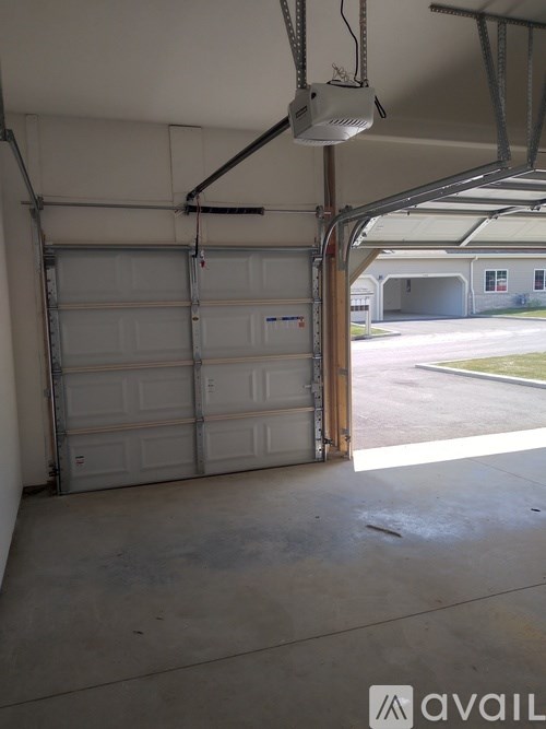 A garage with a closed door and a fan hanging from the ceiling.