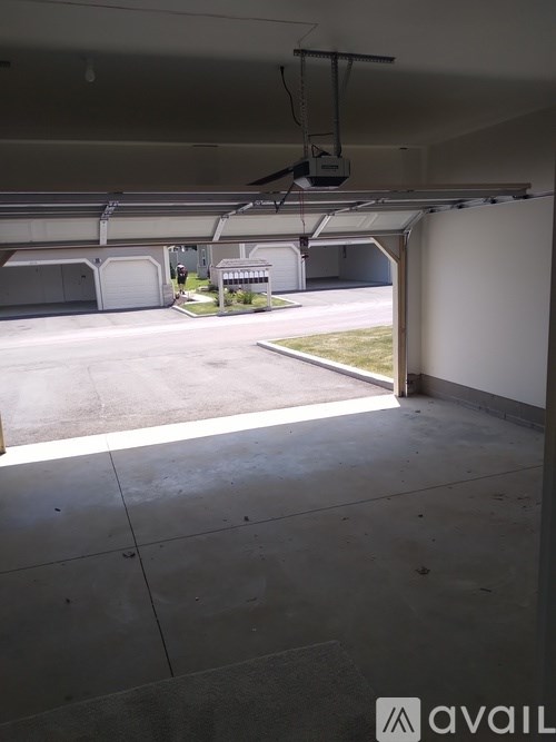 A parking garage with a view of the outside through an open door.