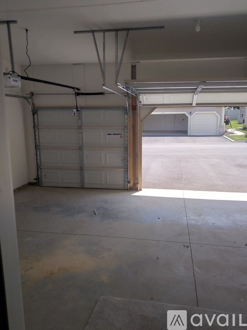 A garage with a white door and a concrete floor.
