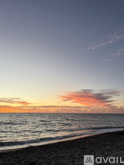 A beach at sunset with waves coming in.